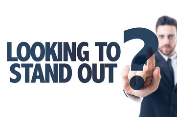 Business man pointing the text: Looking to Stand Out?