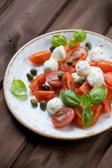 Caprese salad with caper berries, close-up, studio shot