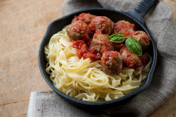 Tagliatelle with meatballs in tomato sauce, studio shot