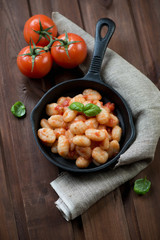 Italian gnocchi with tomato sauce in a frying pan, studio shot