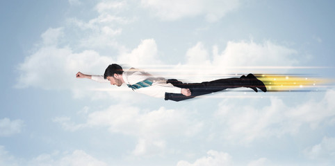 Happy business man flying fast on the sky between clouds