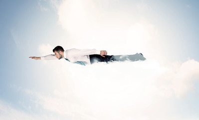 Business man flying like a superhero in clouds on the sky