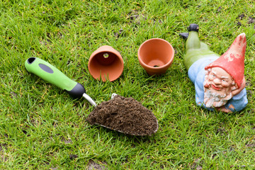 Alter Gartenzwerg und Pflanzutensilien