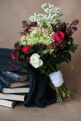 Beautiful bright bridal bouquet lying on a pile of books, decor,