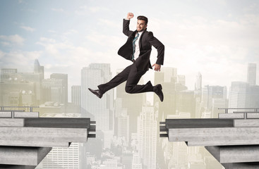 Energetic business man jumping over a bridge with gap