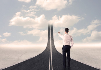Obraz premium Businessman looking at 3d road that goes up in the sky