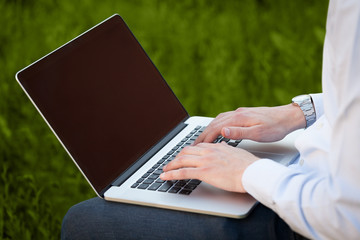 Businessman pressing modern laptop computer on colorful backgrou