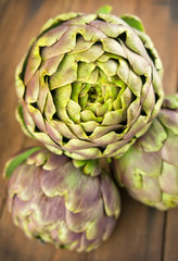 Obraz premium Group of fresh artichokes on wooden table