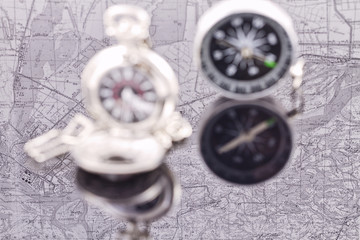 compass and a silver pocket watch on the background reflection m