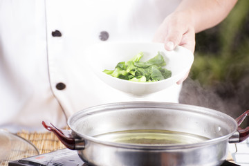 Chef scald vegetable in pot before cooking noodle