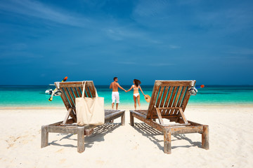 Couple in white running on a beach at Maldives