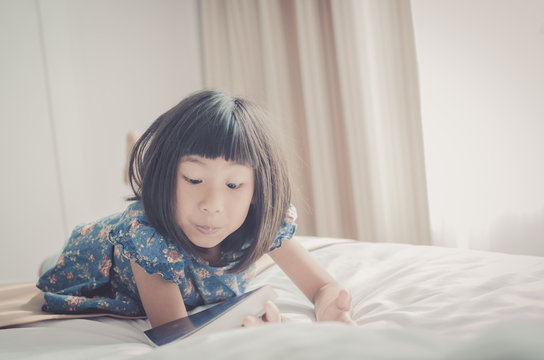 Vintage tone of Young Girl Lying On Her Bed and Reading A Book w