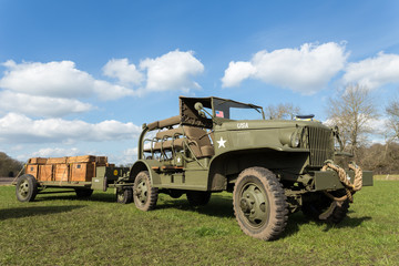 Fototapeta premium Military jeep pulling trailer carrying wooden boxes with bullets