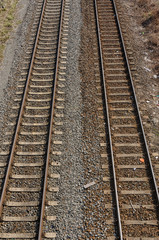 Fototapeta na wymiar two old parallel railway tracks going into distance with gravel