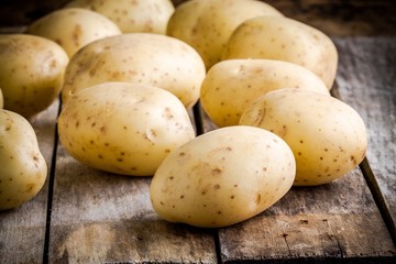 Fresh organic raw potatoes on the old table