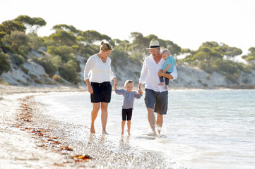 young happy beautiful family walking on beach in Summer holidays