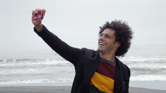 Handsome cool man taking selfie on the beach