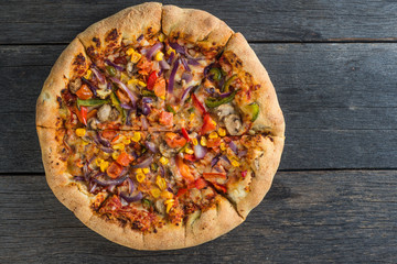 Homemade vegeterian pizza from above on wooden table
