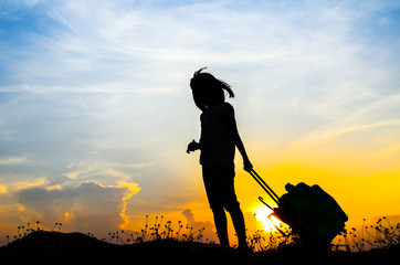 Silhouette Girl with a suitcase with sun set.
