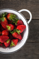 Sweet ripe strawberries in rustic colander