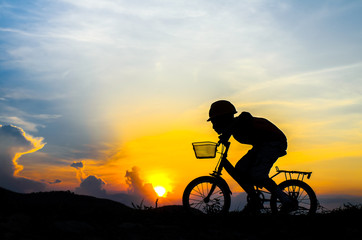 Obraz na płótnie Canvas Silhouette of the cyclist riding a road bike at sunset