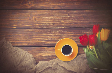 Cup of coffee with tulips near fabric