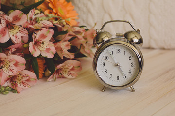 Clock with knitted pillow and flowers