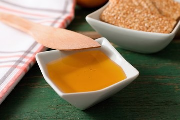 Honey in white bowl on green table