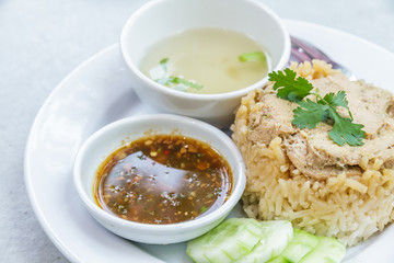Rice roast chicken with spoon and fork on white plate.