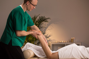 Obraz premium Masseur massaging lower limb