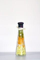 Small bottle with candy and candied fruits and closed stopper is