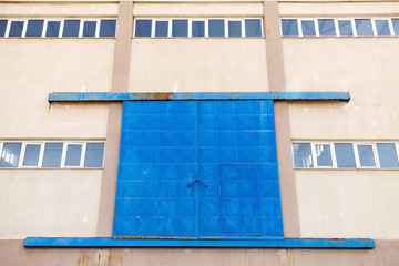 Industrial wall with blue closed metal gate