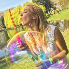 Mädchen macht Seifenblasen im Park