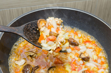cooking pasta with chicken and meat gravy on stove