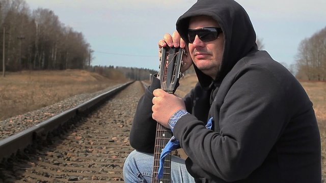 Lonely Man with guitar on the railway