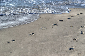 Fototapeta na wymiar footprints by the shore in Alghero
