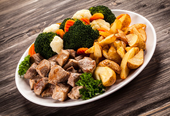 Grilled meat with baked potatoes and vegetables