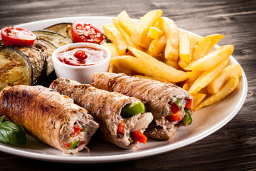 Wrapped pork chop, chips and vegetables