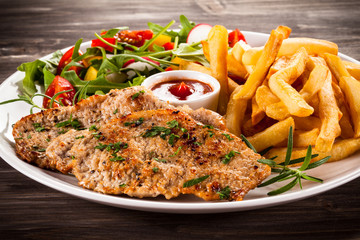 Fried steaks, French fries and vegetables