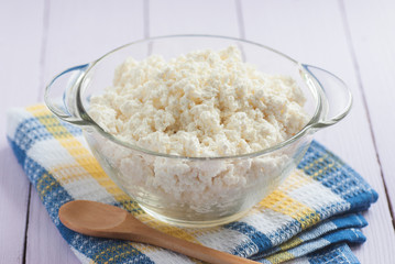 Cottage cheese in a glass with a wooden spoon, close-up, selecti