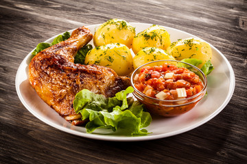Barbecued chicken legs with boiled potatoes and vegetables