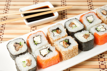 Sushi Assortment On White Dish over bamboo background.