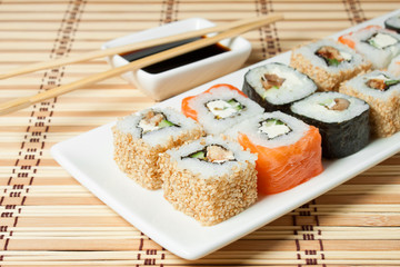 Sushi Assortment On White Dish over bamboo background.