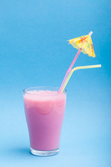 milk smoothie with umbrella on the blue background
