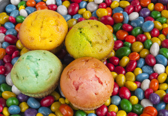 Fototapeta na wymiar delicious muffins on a background of colorful candy