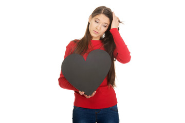 Worried woman with heart made from paper.