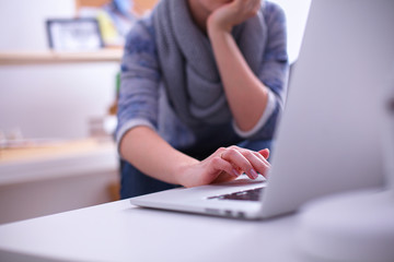 Woman working with a laptop sitting at the desk