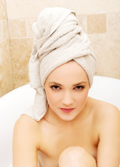 Woman sitting in bathtub.