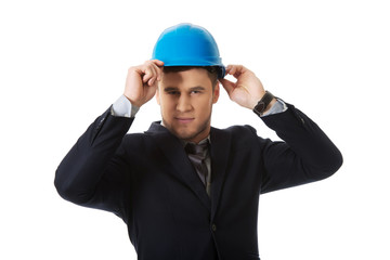 Happy businessman with blue hard hat.