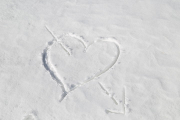 heart pierced by an arrow drawn in the snow